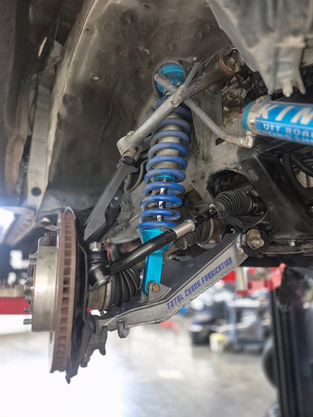 Lexus GX with long-travel suspension build in shop bay